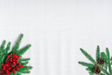Noel tebrik kartı. Beyaz kıvrımlı kağıt üzerinde köknar dalları ve Holly meyveleri. Mesaj, Noel ve yeni yıl için yer