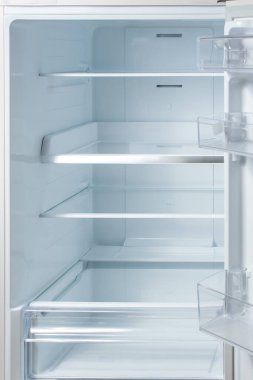 Yeni beyaz buzdolabı. Dolaptaki boş raflar. Sağlık veya diyet konsepti için arka plan. dikey