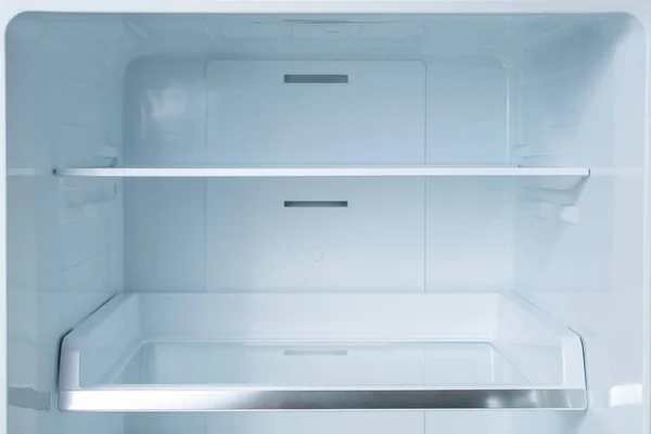 Clean empty shelves in white refrigerator. Empty open fridge with shelves, refrigerator. shelves in empty open white fridge background. background for health or diet concept.