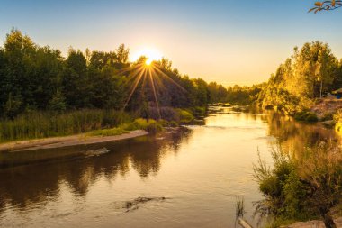 Sonbaharda günbatımında küçük orman nehri. Güzel manzara, nehirde gün batımı. Nehirde altın gün batımı.