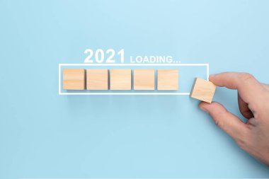 Yeni yıl 2021 'i elle yüklemek, odun küpünü ilerleme çubuğuna koymak. Yeni yıl için yaratıcı bir geçmiş. Yeni yıl 2021 konsepti yükleniyor