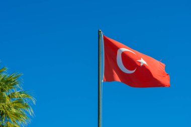 Arka planda gökyüzü olan Türkiye bayrağı rüzgara el sallıyor. Ulusal Türkiye bayrağı sallıyor. Seyahat, turizm.