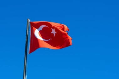 Türk halkının sembolü. Ulusal Türkiye bayrağı sallıyor. Türkiye 'nin ulusal bayrağı mavi gökyüzüne karşı rüzgarda dalgalanıyor.