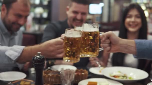 Multietnisk grupp av vänner att ha middag på ett café. ett stort företag har kul tillsammans, skratta och prata. män toast glasögon — Stockvideo