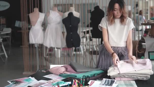 Costureira coloca o tecido sobre a mesa. designer de moda trabalhando no estúdio — Vídeo de Stock