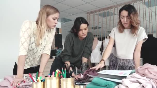 Zakelijke vrouwen zijn bezig met creatief werk. mode-ontwerpers werken in hun kleine Studio. naaisters Kies weefsel voor een nieuwe collectie van kleding — Stockvideo