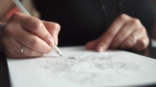 Mestre de tatuagem faz um esboço de tatuagem no papel — Vídeo de Stock