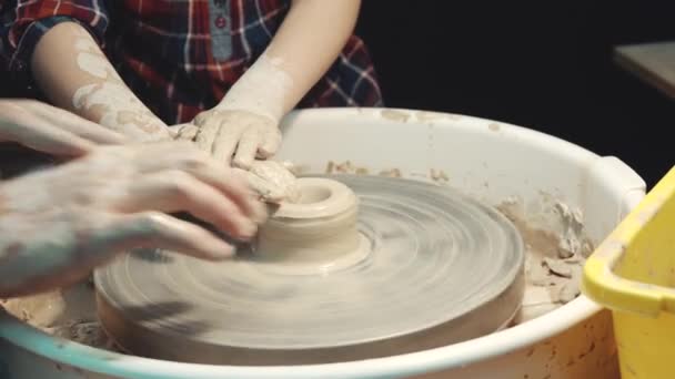 Classe de maître en poterie. l'enseignant apprend à l'enfant à former de l'argile sur une roue Potters — Video