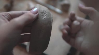 bir kadın bir damga ile kil tabakta desenleri yapıyor. Potters eller yakın çekim