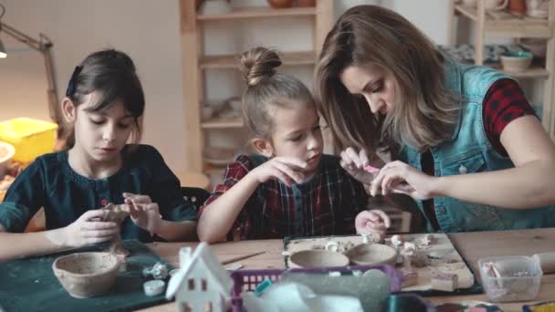 Moeder en dochter enthousiast gekneed uit klei in het aardewerk. — Stockvideo
