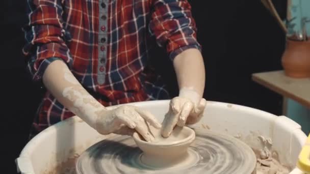 Petite fille sérieuse se concentrant sur la fabrication d'une vaisselle en argile sur une roue de poterie — Video