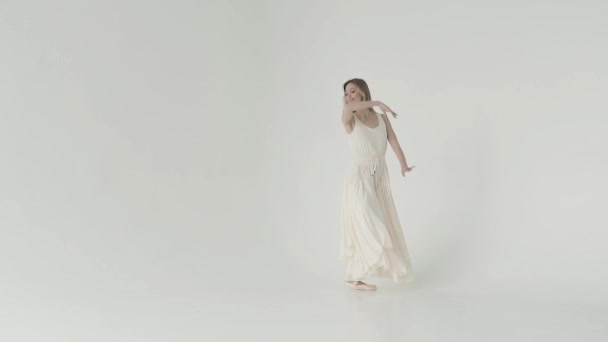 Балерина в белом длинном платье и пуантах танцует классический балет и прыжки в высоту. замедленное движение — стоковое видео