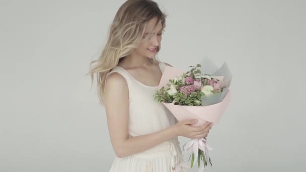Linda joven sosteniendo un hermoso ramo de flores. retrato suave de una hermosa chica de primer plano. cámara lenta — Vídeo de stock