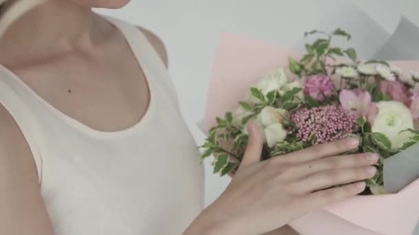 Cute young girl holding a beautiful bouquet of flowers. gentle portrait of a beautiful girl closeup. slow motion — Stock Video