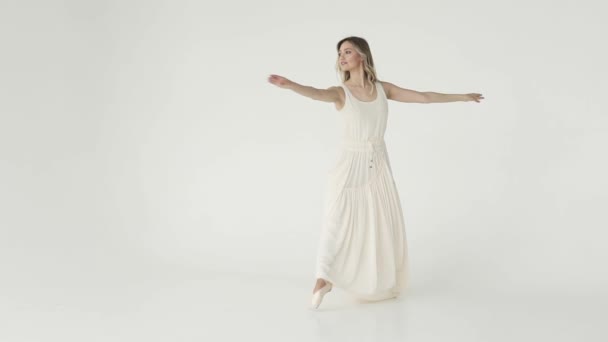 Conceito de beleza, frescura e juventude. bailarina está girando em um vestido de voo leve em um fundo branco. câmara lenta — Vídeo de Stock