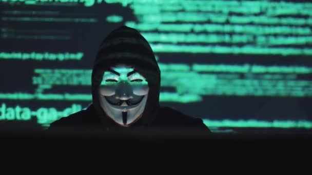 Ο χάκερ στη μάσκα αμυχές το πρόγραμμα. του ψηφιακού εκβιασμού αποκτά πρόσβαση σε πληροφορίες άλλων λαών. επίθεση ιών υπολογιστών. ληστής στο παρασκήνιο τρέχει κώδικα προγράμματος — Αρχείο Βίντεο