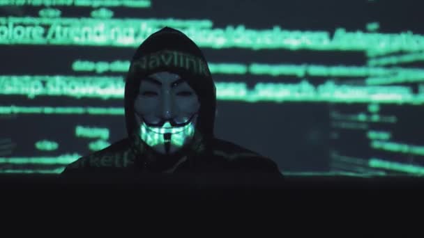 Konzept der Computersicherheit und -sicherheit im Netzwerk. Räuber in der Maske am Computer. Der Hacker knackt den Computercode. Binärcodes Projektionen und Animationen im Hintergrund — Stockvideo