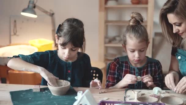 Niños en la lección de cerámica. dos niñas hacen artesanías de barro — Vídeo de stock