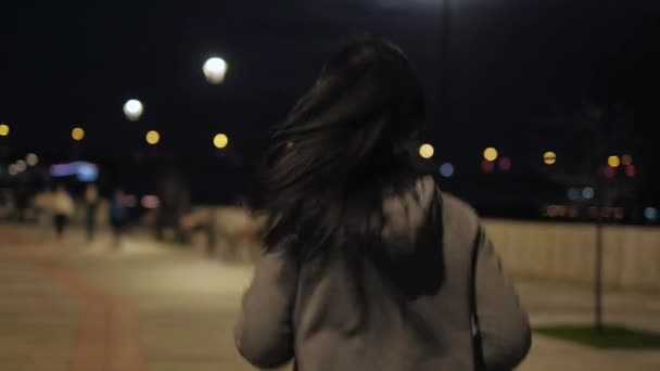 Fille court à travers la ville de nuit et écoute de la musique sur les écouteurs. sports de plein air. course de nuit — Video