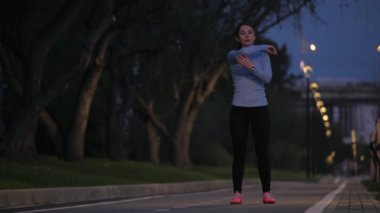 Germe Egzersiz başlamadan önce. akşam parkta koşu önce genç sportif kız ısıtır