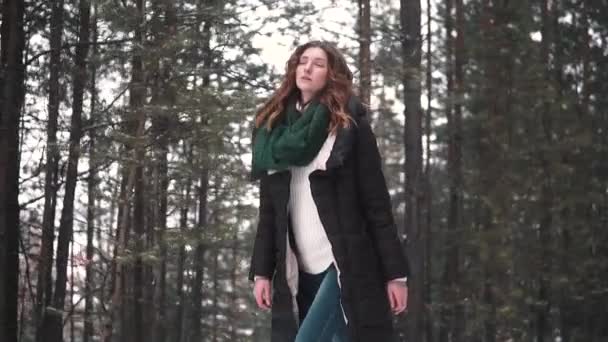 Porträt eines rothaarigen Mädchens, das durch einen Winterwald geht — Stockvideo