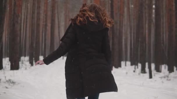 Ritratto di una ragazza dai capelli rossi con un aspetto elfico in una foresta invernale. ragazza corre attraverso la foresta invernale e si guarda intorno. rallentatore — Video Stock