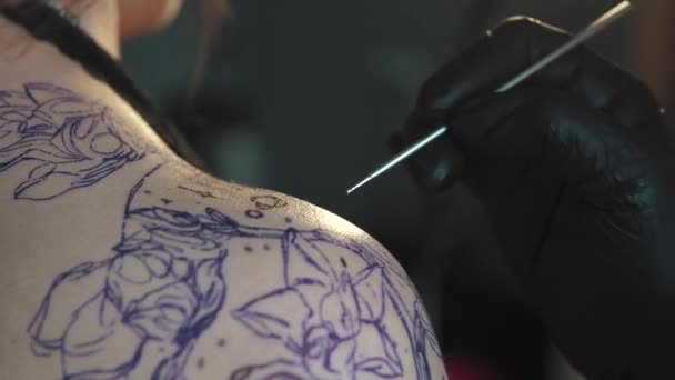 Desenhar uma tatuagem no ombro de perto. tatuagem mestre faz uma metralhadora de tatuagem rotativa — Vídeo de Stock