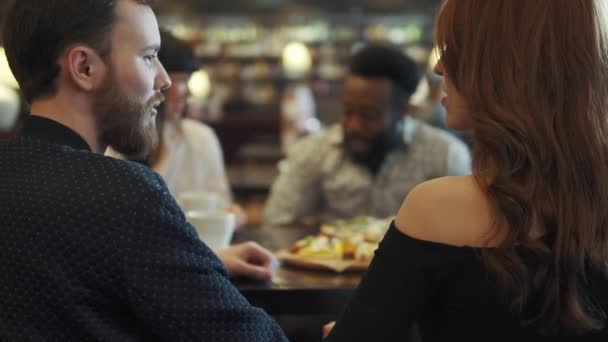 Czterech przyjaciół przy stoliku w kawiarni lub restauracji. przyjaciele spędzają razem czas, rozmawiając — Wideo stockowe