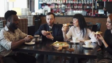 çok etnik gruptan oluşan şirket bir kafe ya da restoran gör. arkadaşlar ve konuşma birlikte eğlenin. iki kız ve bir sıcak kahve evde bir masada iki adam