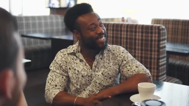 Portrait d'un jeune homme noir à table dans un café ou un restaurant — Video