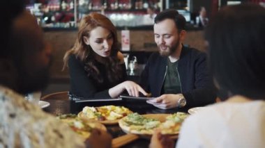 arkadaş birlikte Şirket restoranda öğle yemeği zaman harcamak. adam ve kız yemekleri menüden seçin.