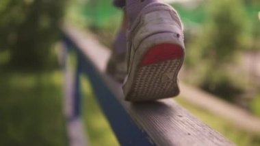 Çocuk bacaklar yakın çekim. çocuk üzerinde kol demiri ve havada dengeler. mutlu ve huzurlu bir çocukluk kavramı. ağır çekim