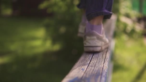 Childrens legs close-up. the child is on the crossbar and balances in the air. the concept of a happy and serene childhood. slow motion — Stock Video
