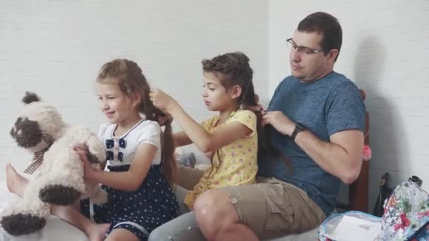 Papá y dos hijas en casa. padre pasa tiempo con los niños. padre hace coletas para su hija — Vídeos de Stock