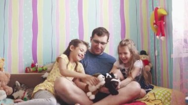 Genç baba ve iki küçük kızım yumuşak oyuncaklar, gülümseme ve kahkaha ile oynamak. Baba zaman çocuklarla sahiptir.