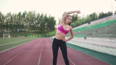 sporcumuz önce eğitim ısıtır. Stadyumun çalıştırmadan önce germe yapmak spor giysileri kızı. ağır çekim