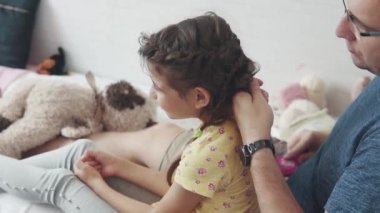 Genç baba küçük kızı ile vakit geçiriyor. Baba pigtails bezleri, onunla çalış ve aptallar