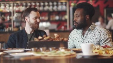 çok etnik gruptan oluşan bir grup arkadaşıyla bir restoranda. bir kafede bir masada iki arkadaş