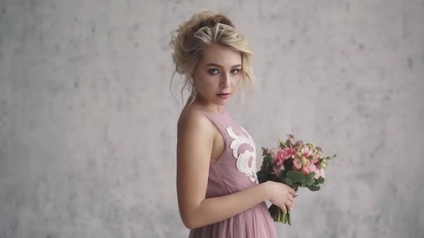 Portrait of a young girl in an evening gown. evening make-up and a beautiful hairstyle. charming blonde in a dress with an open back — Stock Video