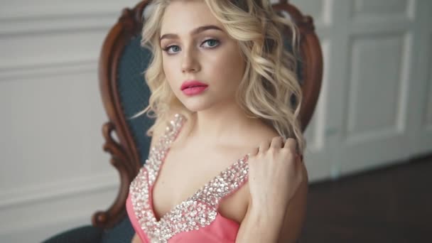 Sensuella porträtt av en blondin med blå ögon. attraktiva flicka med kvällsmakeup och hår poserar för kameran — Stockvideo