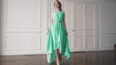 yeşil giysili bir genç kız. güzel makyaj ve saç ile çekici bir esmer portresi. kız bir elbiseyle iplik. ağır çekim