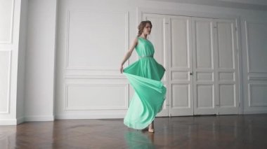 Kız güzel çırpınır uzun bir elbise içinde dönüyor. ağır çekim