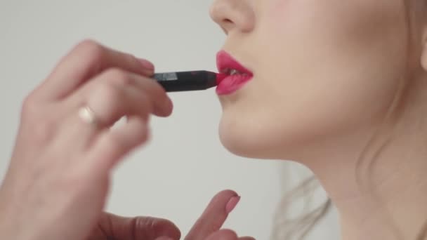 Kadeřnice dělá make-up modelu. dívka v šatech koktejl se připravuje na oslavu — Stock video