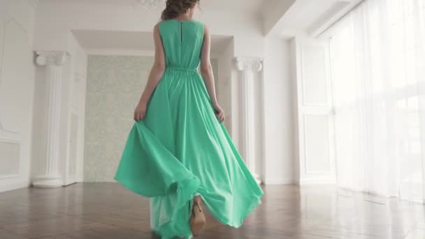 A fashionable girl in a fluttering dress go away from the camera and looks around. the fabric flutters beautifully. slow motion — Stock Video