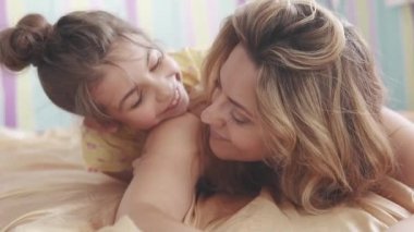 Genç Anne ve küçük kızı sarılma ve gülüyor