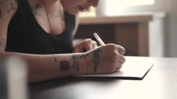 Tatoueur fait un croquis de tatouage sur papier dans un studio à la maison — Video