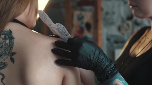 Drawing a tattoo on the shoulder close up. master tattoo makes a rotary tattoo machine gun — Stock Video