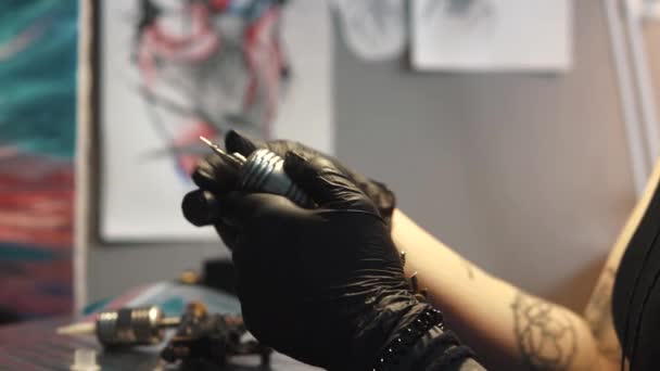Καλλιτέχνης τατουάζ συλλέγει το μηχάνημα τατουάζ. κορίτσι τατουάζ πλοίαρχος ετοιμάζει ένα πολυβόλο περιστροφική τατουάζ για την κατάρτιση ενός σχεδίου πάνω στο δέρμα — Αρχείο Βίντεο