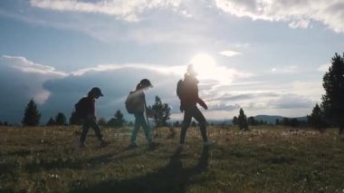 Aile turist bir yolculuğa. Kampanya iki kızı annesiyle. sırt çantaları çocuklarla dağlar manzarayı. dağlarda çocuklu genç kadın gider.