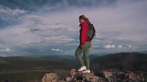 Chica viajera llegando al borde del acantilado en las montañas y disfrutando de la hermosa vista — Vídeos de Stock